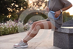 Young woman with stylish bum bag outdoors, closeup