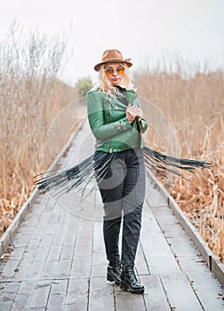 Young woman stylish dressing in eco leather jacket at nature