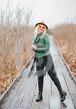 Young woman stylish dressing in eco leather jacket at nature