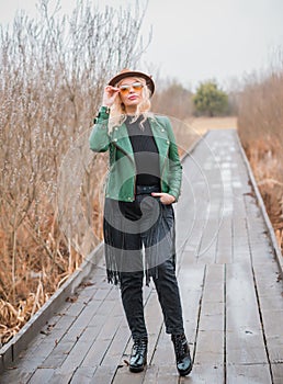 Young woman stylish dressing in eco leather jacket at nature