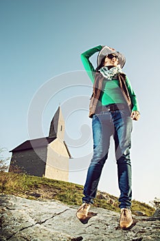 Young woman with stylish hat and an old romanesque church Archangel Michael