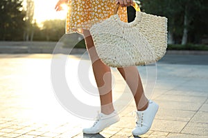 Young woman with stylish straw bag outdoors, closeup