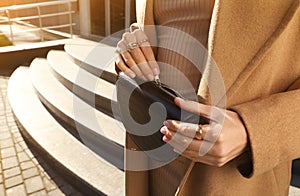 Young woman with stylish waist bag on city street, closeup. Space for text