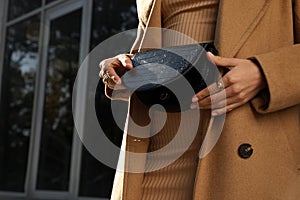 Young woman with stylish waist bag outdoors, closeup