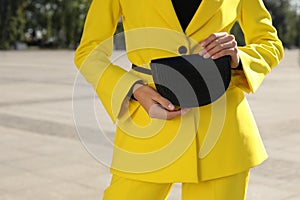 Young woman with stylish waist bag outdoors, closeup