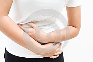 Young woman suffering from abdominal pain feeling stomachache, symptom of pms on white background photo