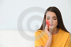 Young woman suffering from acute toothache on white background , space for text