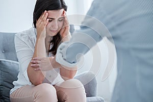 Young woman suffering from depression crying in her therapist`s