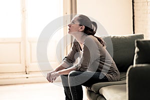 Young woman suffering from depression feeling sad and lonely on sofa at home