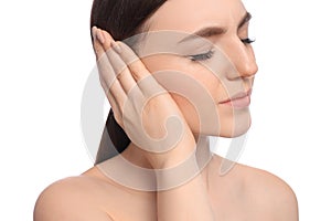 Young woman suffering from ear pain on white background, closeup