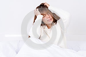 Young woman suffering from headaches after wake up on the bed. Healthcare medical or daily life concept