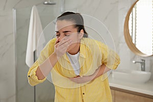 Young woman suffering from nausea in bathroom. Food poisoning