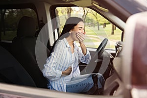 Young woman suffering from nausea in car