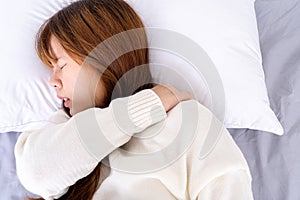 Young woman suffering neck and shoulder pain from uncomfortable bed. Healthcare medical or daily life concept