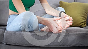 Young woman suffering from pain in foot