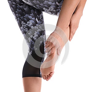 Young woman suffering from pain in foot on white background, closeup