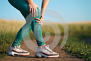 Young woman suffering from pain in her knee