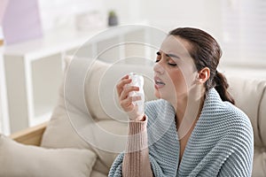 Young woman suffering from runny nose in room