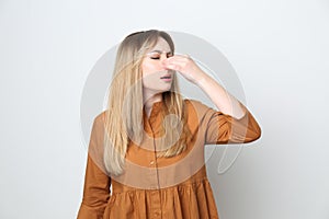 Young woman suffering from runny nose on white background