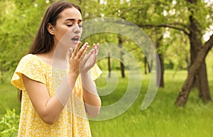 Young woman suffering from seasonal allergy outdoors