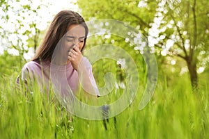 Young woman suffering from seasonal allergy outdoors