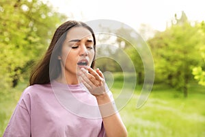 Young woman suffering from seasonal allergy, space for text