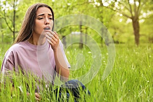 Young woman suffering from seasonal allergy outdoors