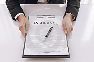 Young woman in suit in his office showing an insurance policy an
