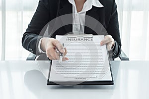 Young woman in suit in his office showing an insurance policy an