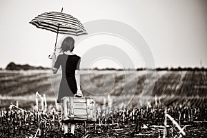 Young woman with suitcase and umbrella
