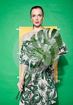 Young woman in summer dress holding leaf