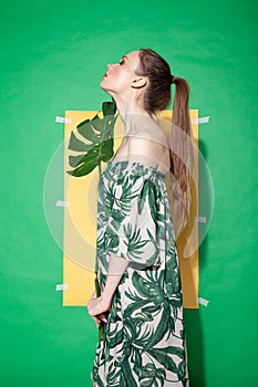 Young woman in summer dress holding leaf