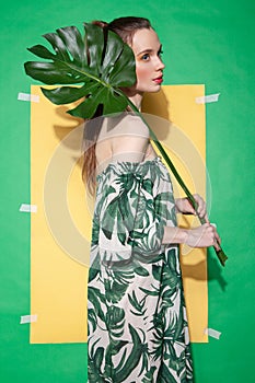 Young woman in summer dress holding leaf