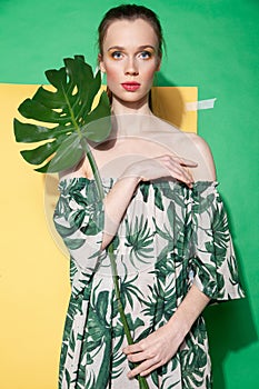 Young woman in summer dress holding leaf