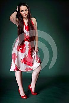 Young woman in summer flowery dress on green