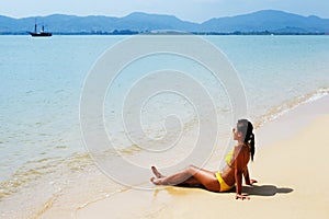 Young woman sun bathing on a sandy beach of Thailand