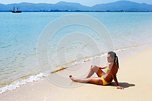 Young woman sun bathing on a sandy beach of Thailand