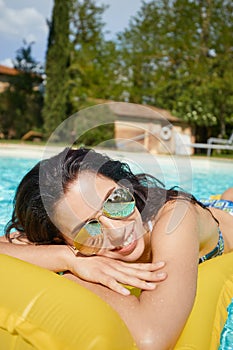 Young woman sun bathing in spa resort swiming pool photo