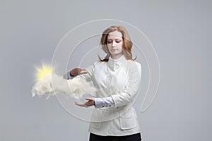 Young woman and sun shining out from behind the clouds, cloud computing or weather concept