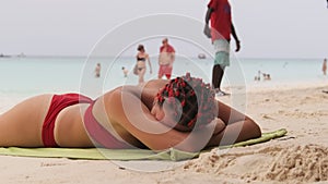 Young Woman Sunbathes on a Paradise Sandy Beach Lying in Red Bikini near Ocean