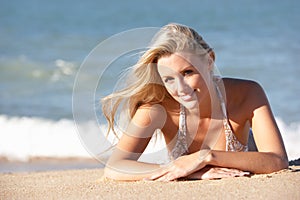 Young Woman Sunbathing On Beach photo