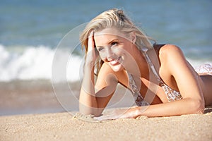 Young Woman Sunbathing On Beach