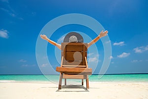 Young woman sunbathing on lounger at tropical beach