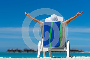 Young woman sunbathing on lounger at tropical beach