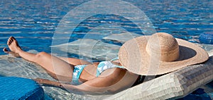 Young Woman Sunbathing in the Pool