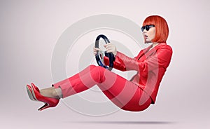 Young woman in sunglasses driver car with a wheel