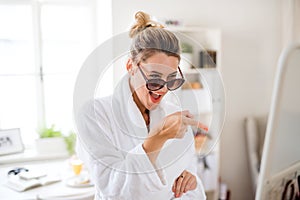 Young woman with sunglasses indoors at home in the morning, having fun.