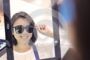 Young woman in sunglasses looking at camera in shop.