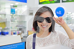 Young woman in sunglasses looking at camera in shop.