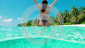 Young woman in sunglasses relaxes in azure ocean water